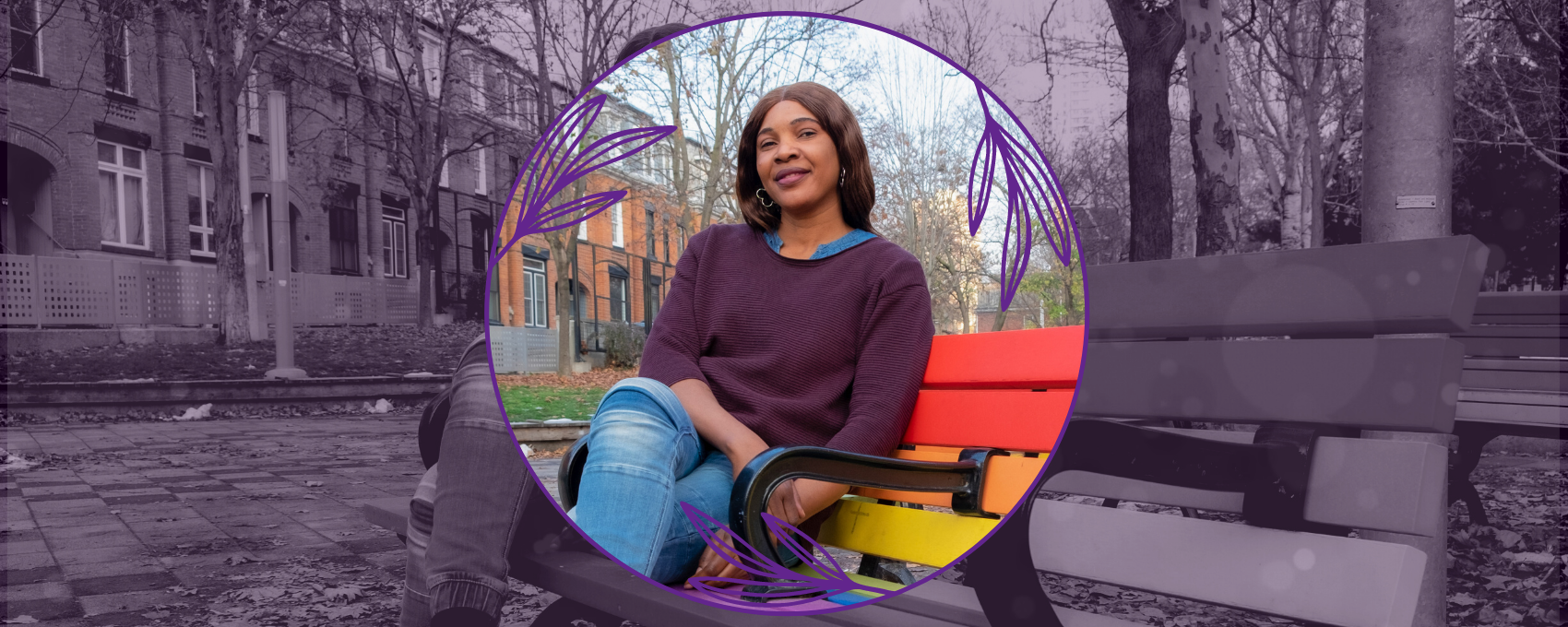 Gloria sitting on a bench painted in pride flag colours